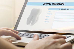 Filling out dental insurance form on a laptop